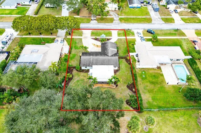 an aerial view of a house with a garden and lake view