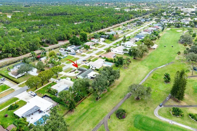 an aerial view of residential houses with outdoor space and trees