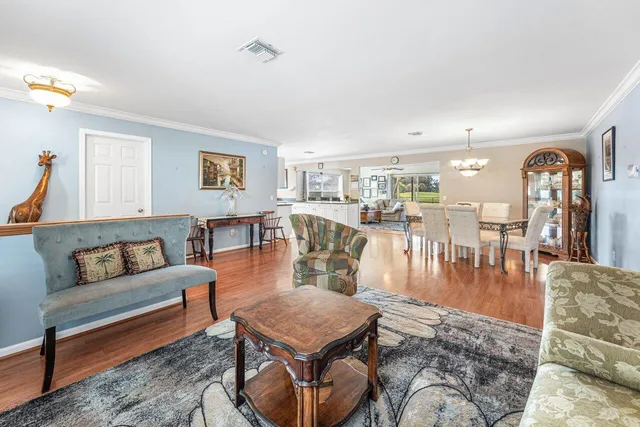 a living room with furniture wooden floor and a table