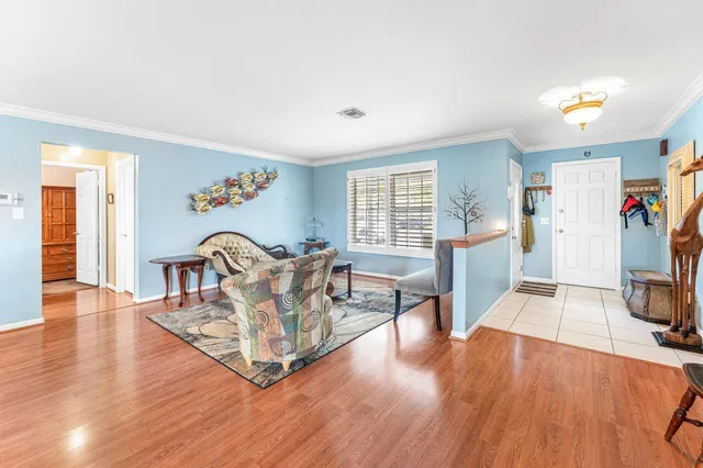 a living room with furniture and a wooden floor