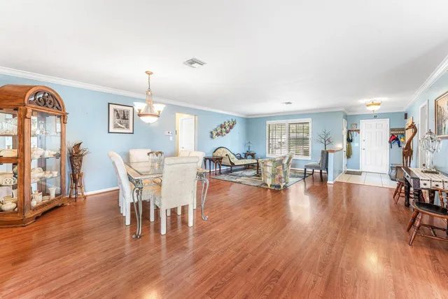 a living room with furniture and wooden floor to ceiling window