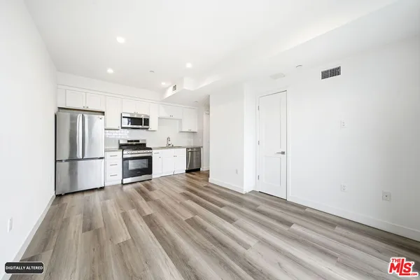 a kitchen with white cabinets and stainless steel appliances