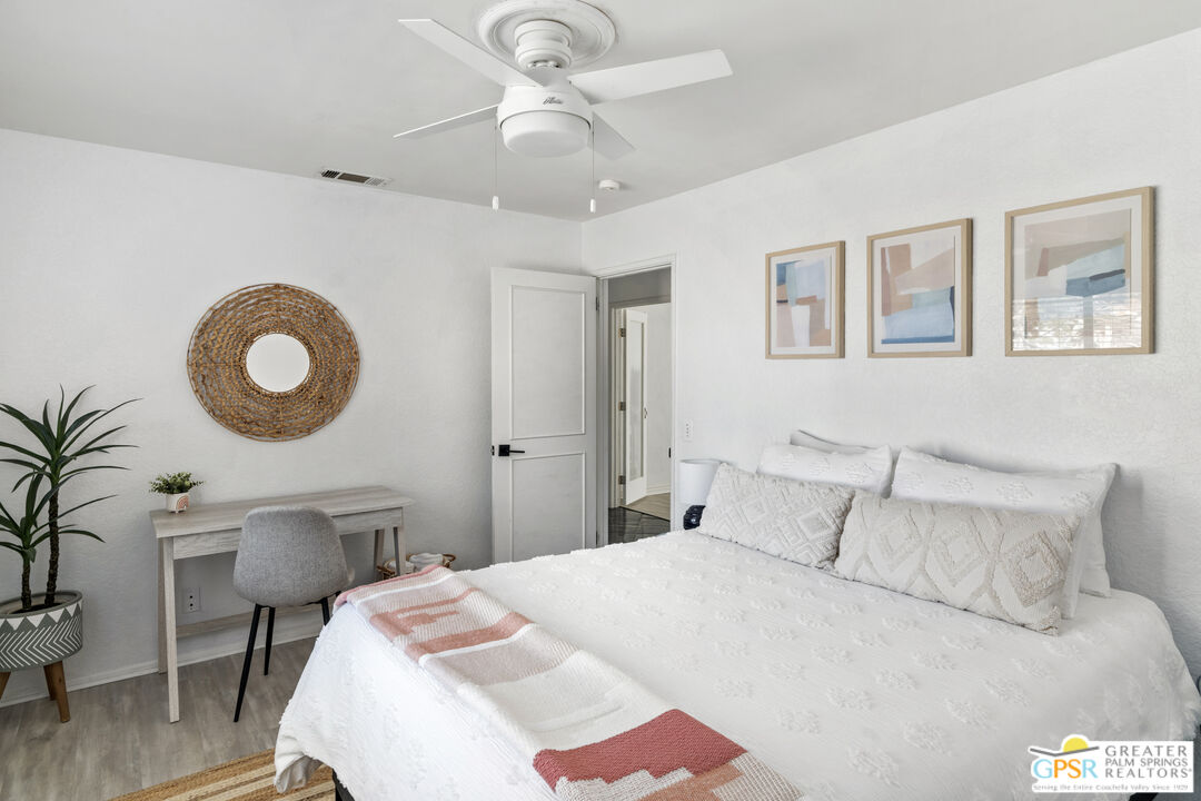 2493 East Powell Road Palm Springs, CA 92262 - Photo 14 of 43 a bedroom with a bed and a chandelier