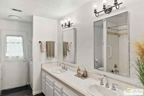 a bathroom with a double vanity sink and mirror