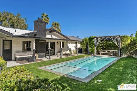 a view of a house with swimming pool and sitting area