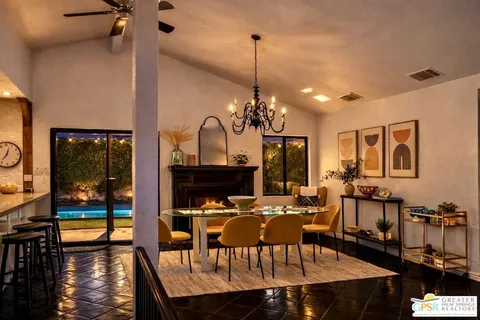 a view of a dining room and livingroom with furniture wooden floor a chandelier