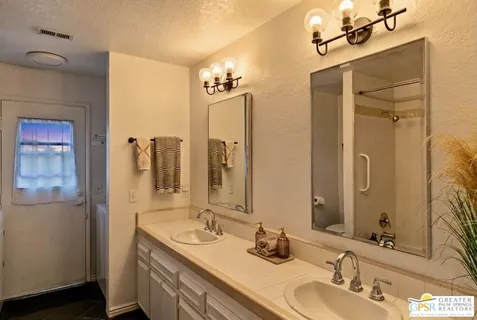 a bathroom with a double vanity sink and a mirror