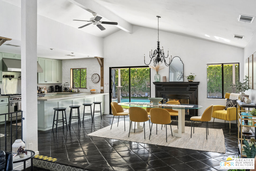 2493 East Powell Road Palm Springs, CA 92262 - Photo 7 of 43 a dining room with furniture a fireplace and a chandelier