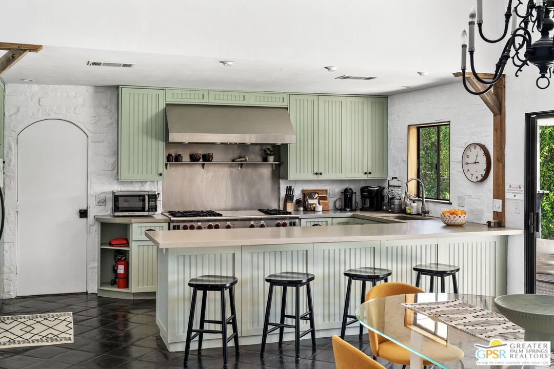 2493 East Powell Road Palm Springs, CA 92262 - Photo 9 of 43 a kitchen with granite countertop a table and chairs