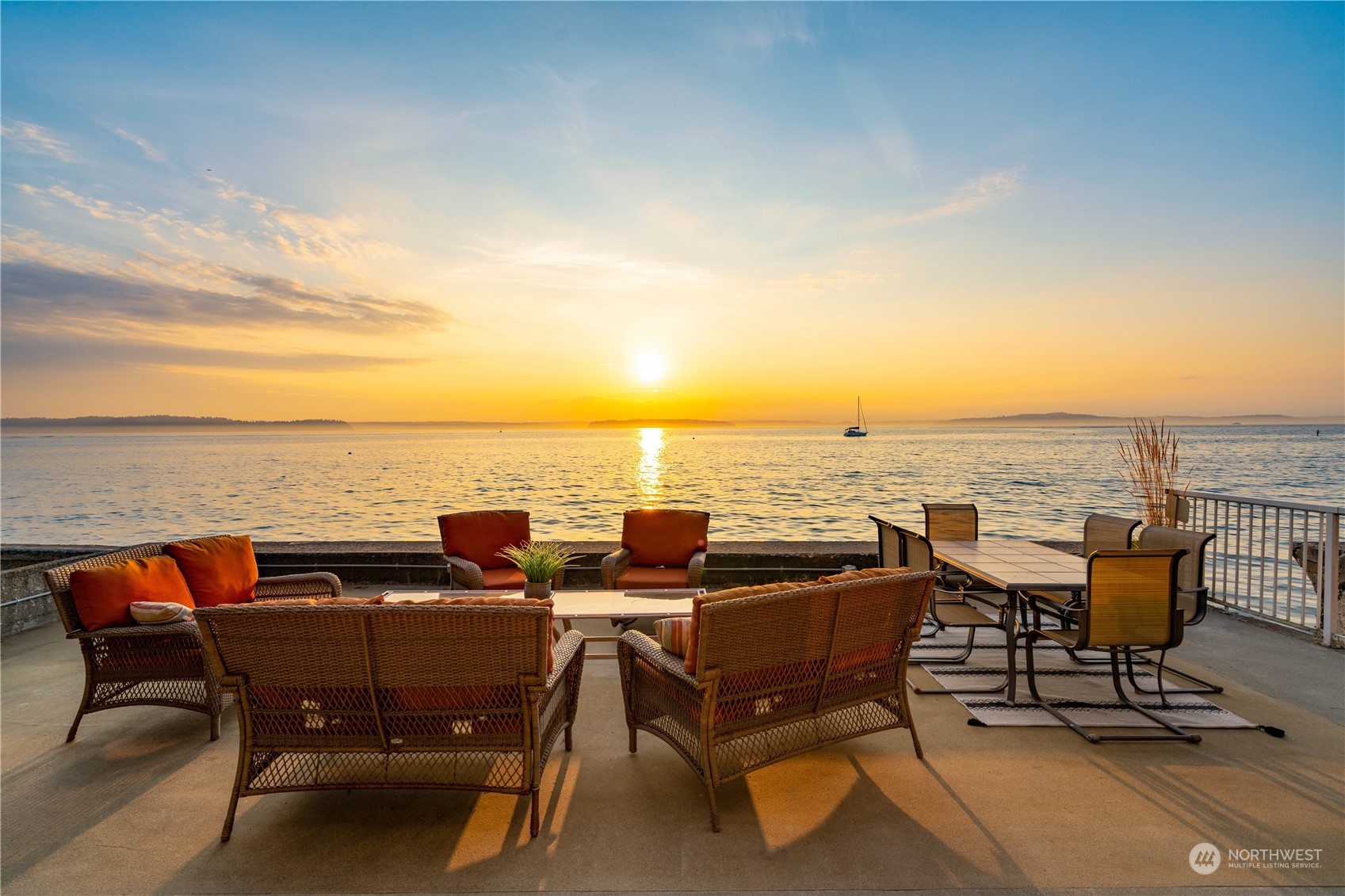 an outdoor sitting area with furniture and ocean view