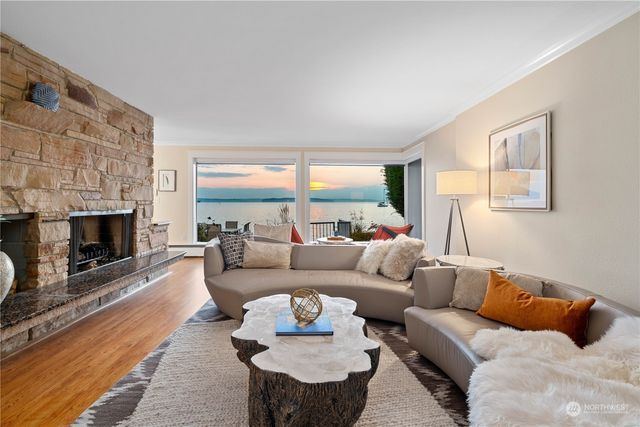 a living room with furniture a fireplace and a large window