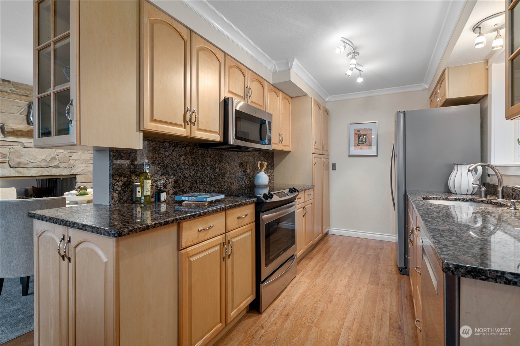 7127 Beach Drive Southwest Seattle, WA 98136 - Photo 17 of 33 a kitchen with stainless steel appliances granite countertop a stove a sink dishwasher and a refrigerator with wooden floor