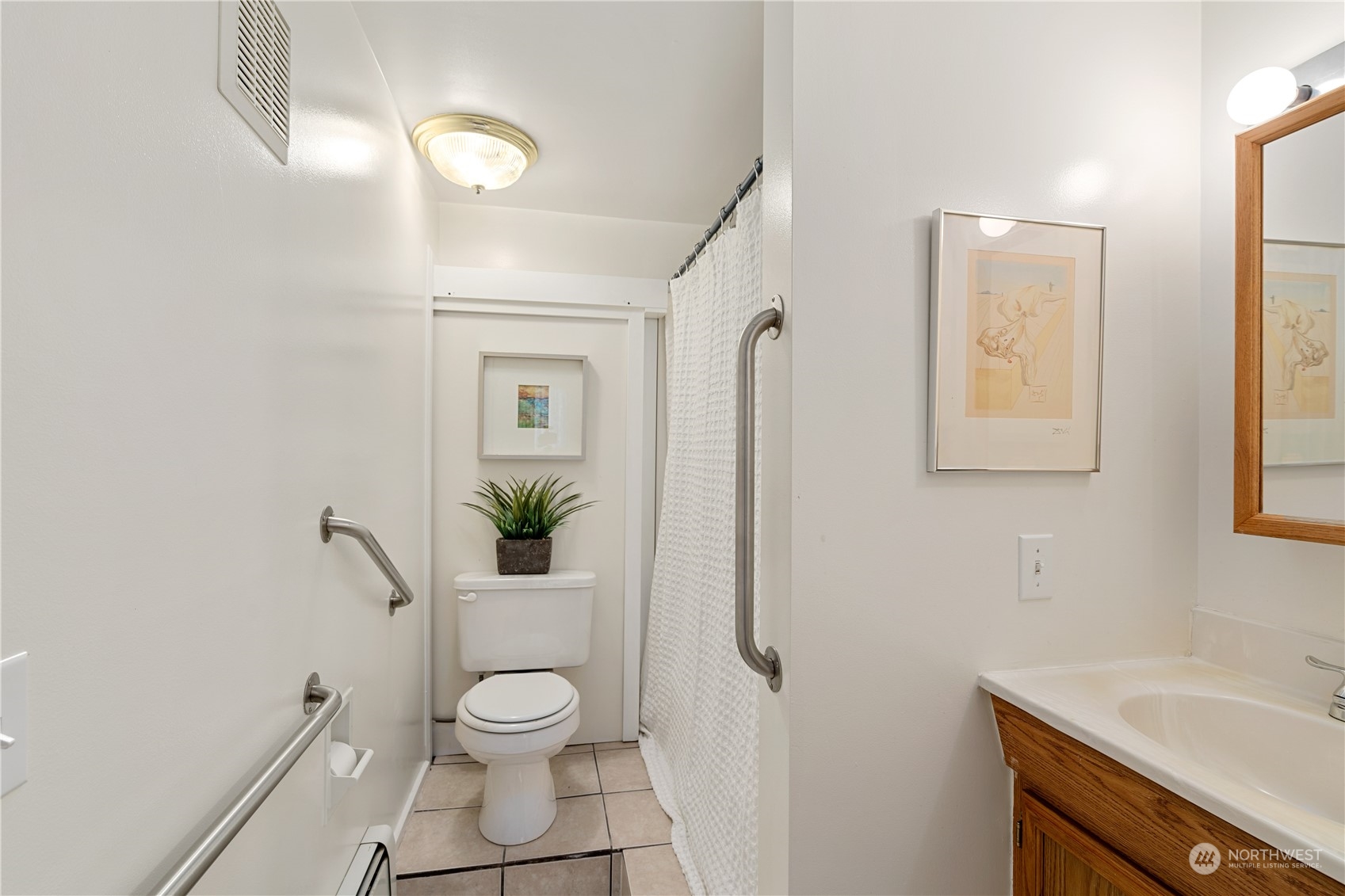 7127 Beach Drive Southwest Seattle, WA 98136 - Photo 32 of 33 a bathroom with a granite countertop toilet a sink and a mirror