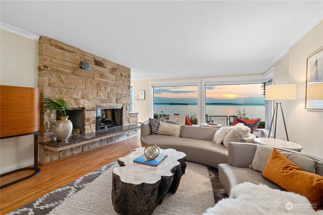 a living room with furniture a fireplace and a large window