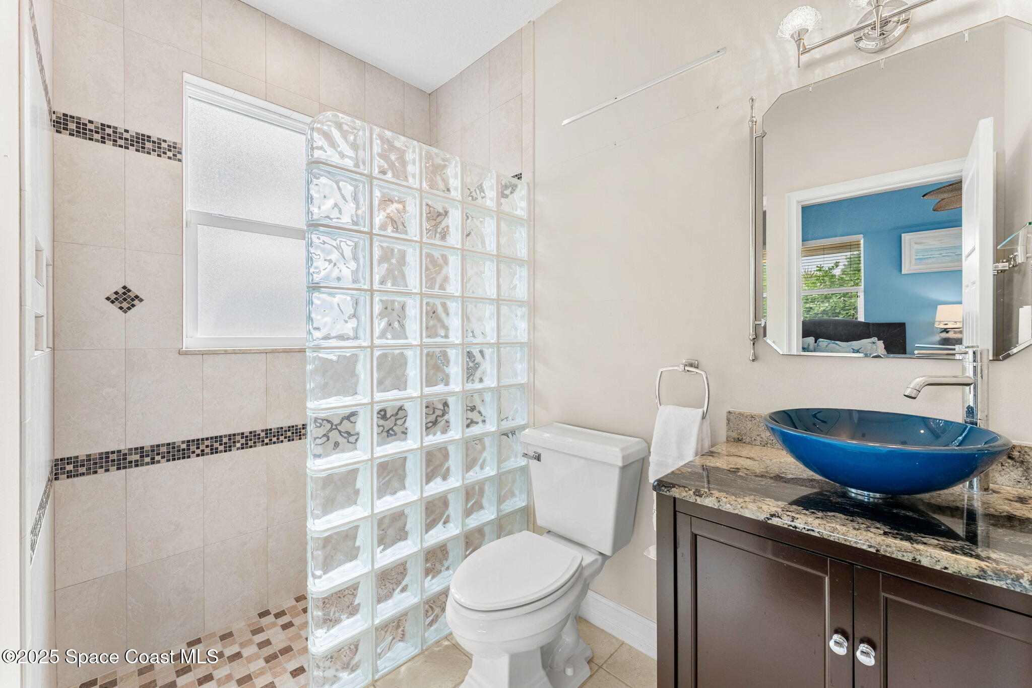 5795 Florida A1A Melbourne Beach, FL 32951 - Photo 36 of 71 a bathroom with a granite countertop sink a toilet a mirror and shower