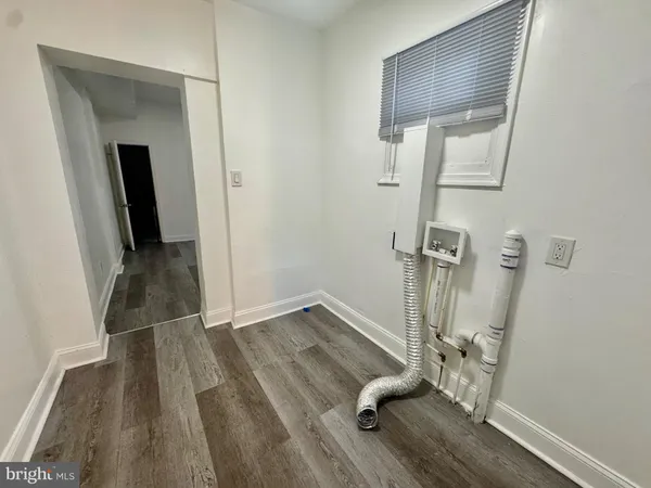 a view of a hallway with wooden floor and entryway