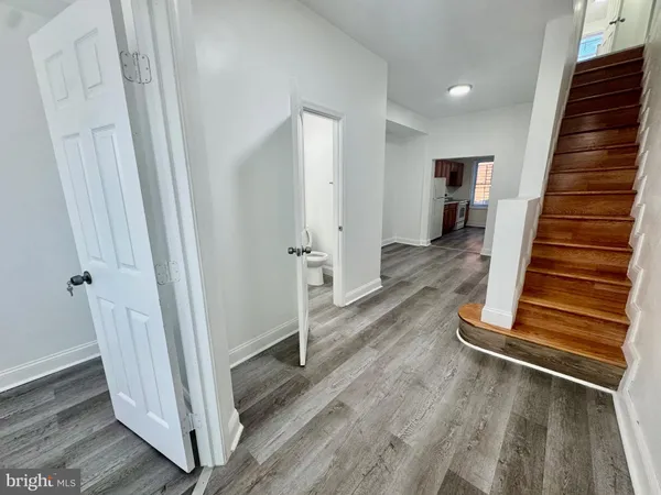 a view of a hallway with wooden floor and staircase