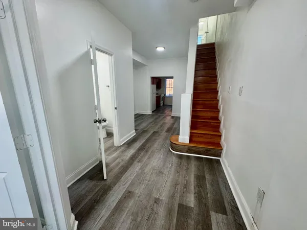 a view of a hallway with wooden floor and staircase
