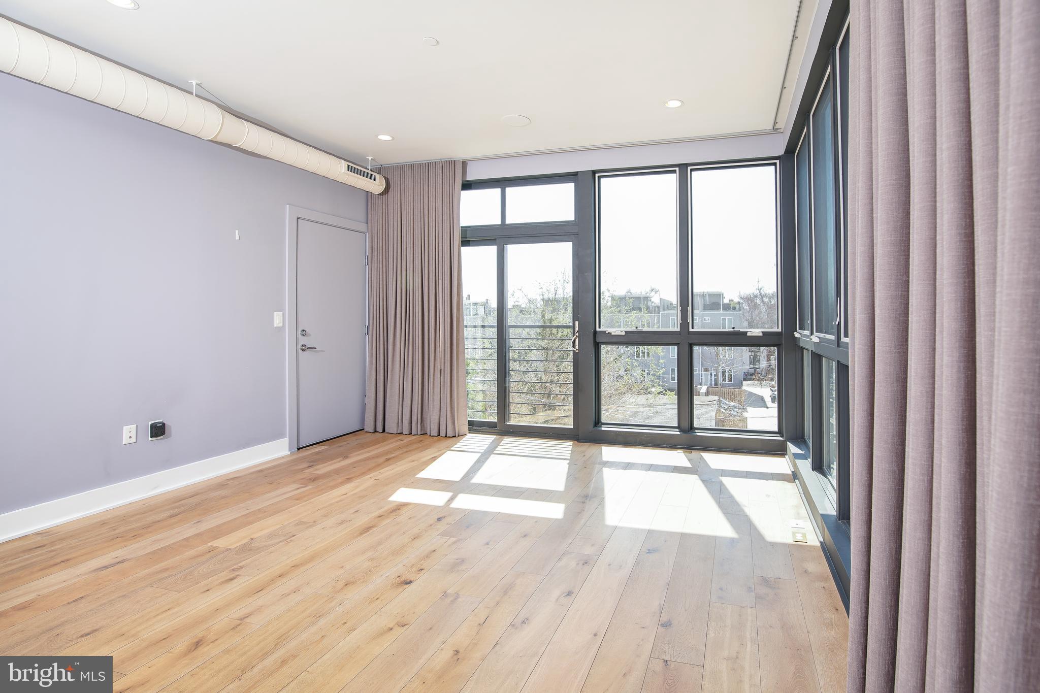 1012 Harvard Street Northwest, Unit 8 Washington, DC 20001 - Photo 5 of 34 a view of an empty room with wooden floor and a window