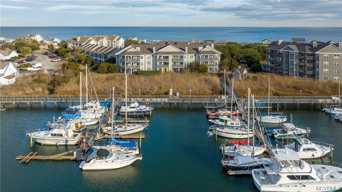 1003 High Dunes Quay, Unit 101 Hampton, VA 23664 - Photo 4 of 42 a living room with lots of white furniture and a table