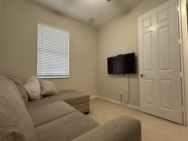 a bedroom with furniture and a flat screen tv