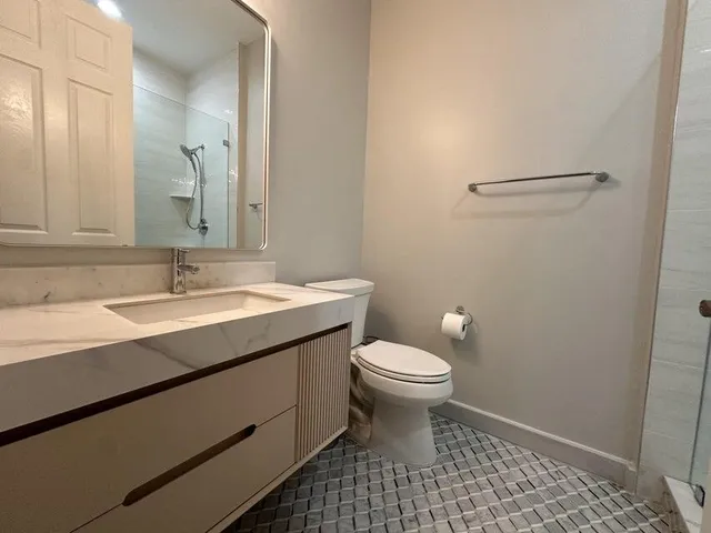 a bathroom with a sink a toilet and a mirror