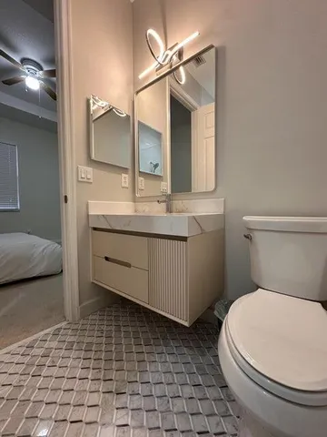a bathroom with a toilet a sink and mirror