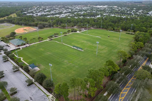 a view of a tennis ground with a white house