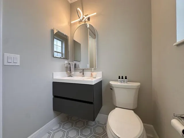a bathroom with a toilet sink and mirror