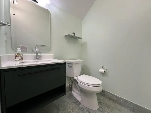 a bathroom with a sink toilet and a mirror