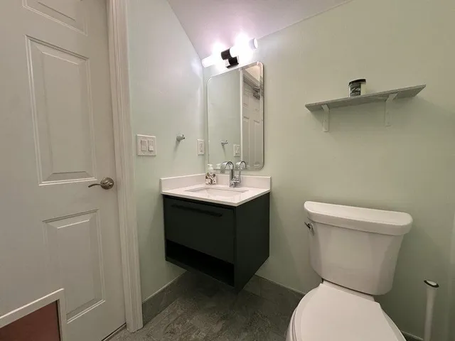 a bathroom with a toilet sink and mirror