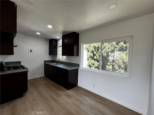 a kitchen with stainless steel appliances granite countertop a stove a sink and a large wooden floors