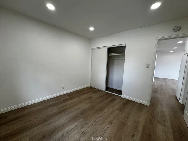an empty room with wooden floor and entrance