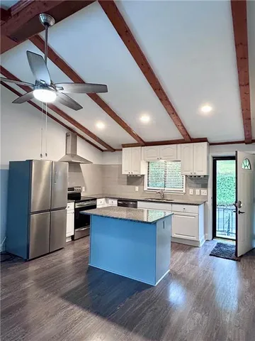 a kitchen with stainless steel appliances granite countertop a stove and a refrigerator
