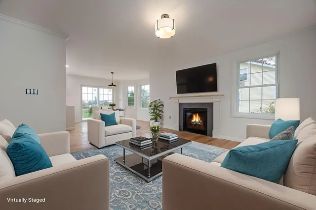 a living room with furniture a flat screen tv and a fireplace