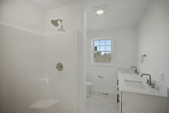 a bathroom with a shower sink and mirror