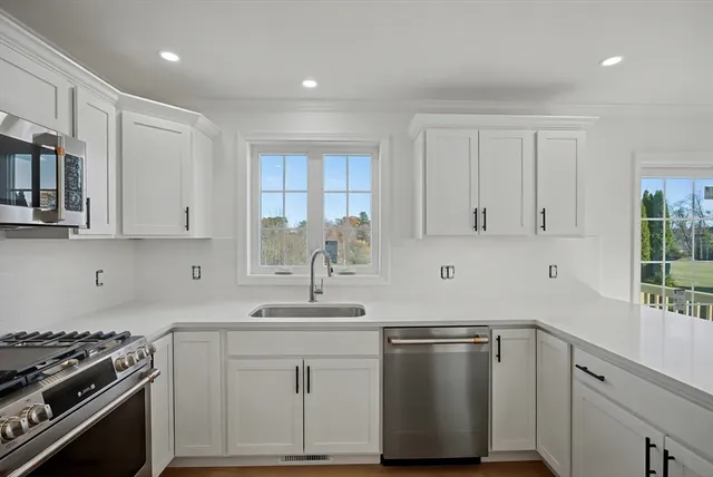 a kitchen with stainless steel appliances granite countertop a sink stove and cabinets
