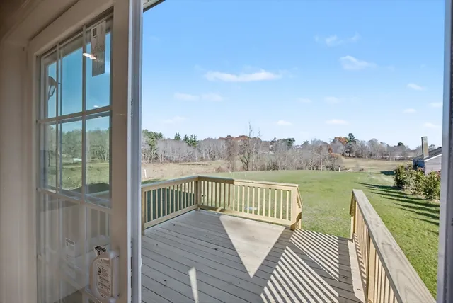 a view of a balcony with wooden floor next to a lake