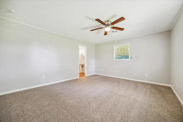 a view of a room with a ceiling fan and window