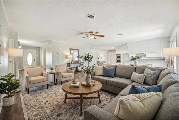 a living room with furniture kitchen view and a table
