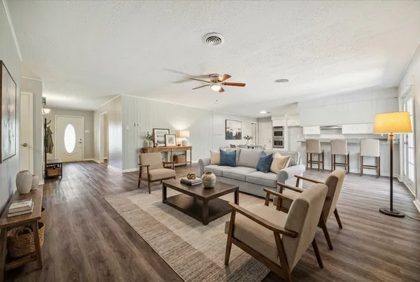 a living room with furniture and a wooden floor