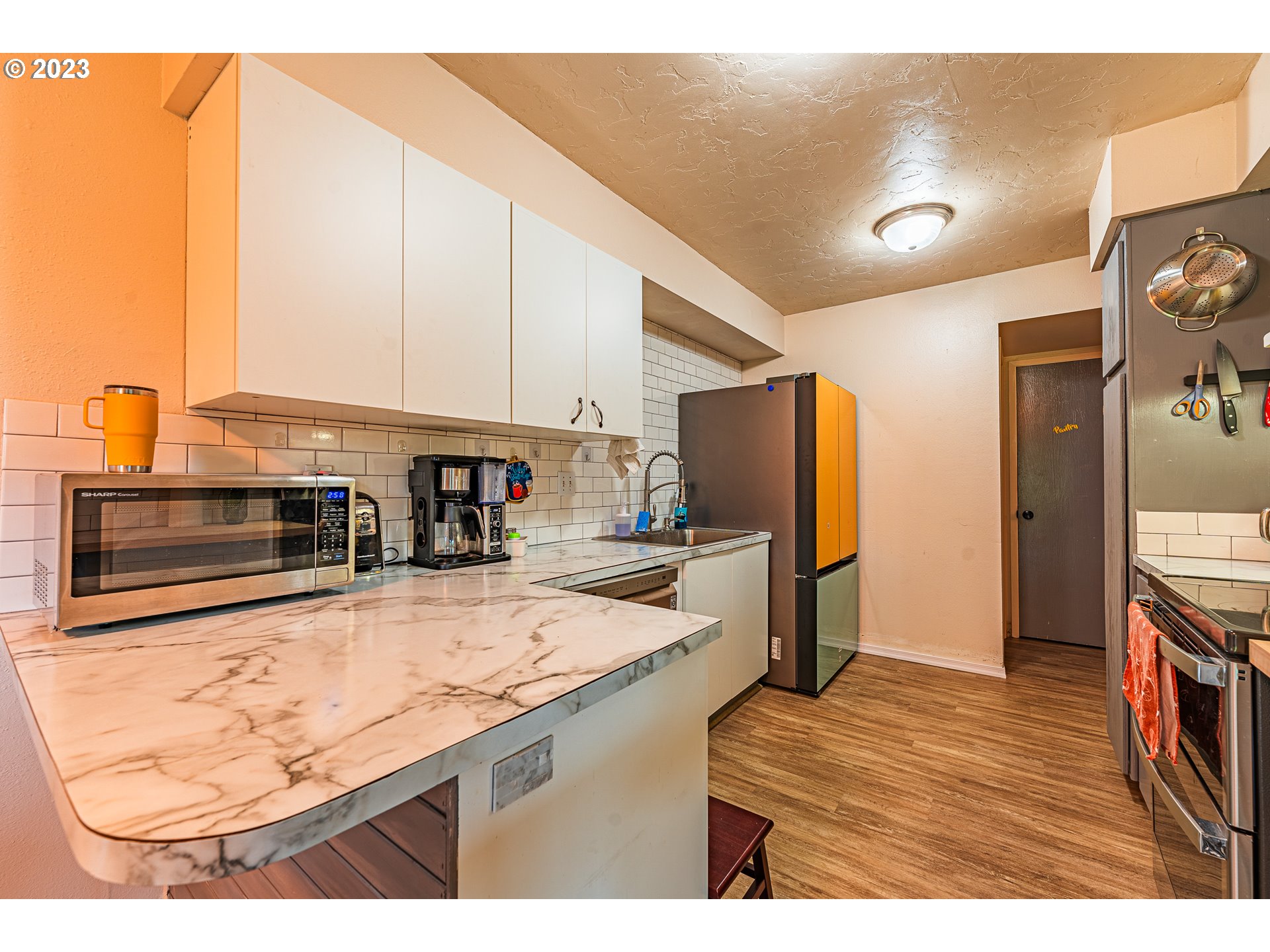 2727 Gateway Street, Unit 48 Springfield, OR 97477 - Photo 8 of 25 a kitchen with stainless steel appliances kitchen island granite countertop a refrigerator a stove and a sink with wooden floor