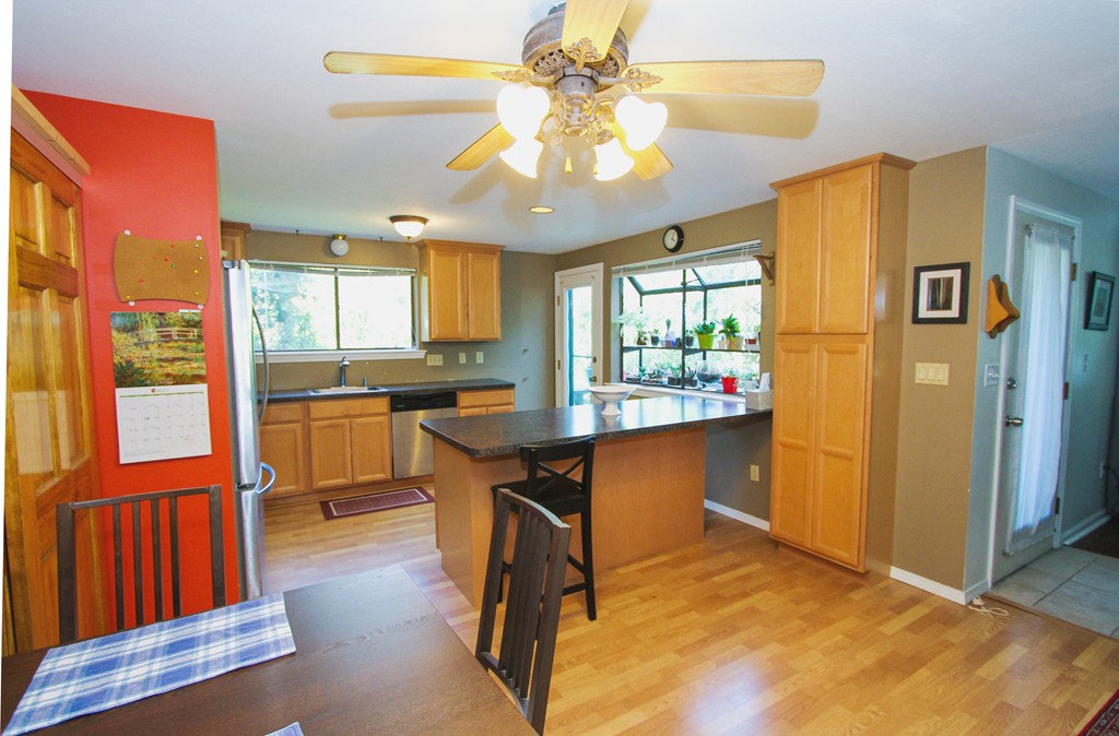 41 Leland Farm Road, Unit 41 Ashland, MA 01721 - Photo 4 of 9 a kitchen with stainless steel appliances granite countertop a refrigerator a sink dishwasher and a dining table with wooden floor