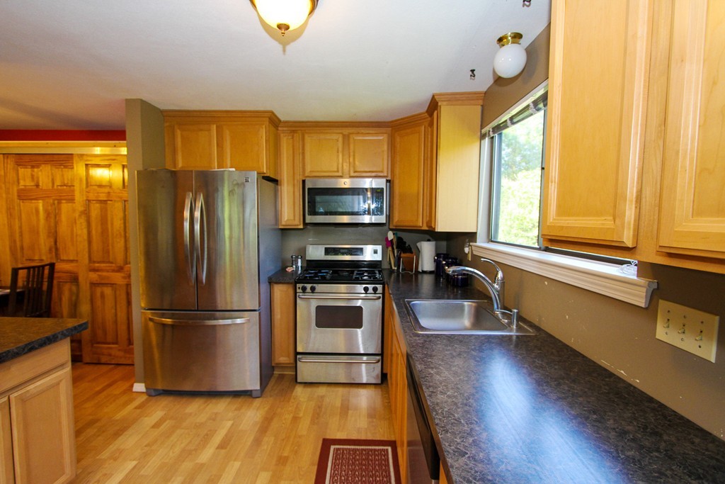 41 Leland Farm Road, Unit 41 Ashland, MA 01721 - Photo 5 of 9 a kitchen with granite countertop stainless steel appliances a sink and a refrigerator