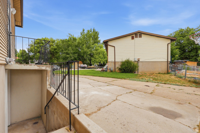 629 King Circle Layton, UT 84041 - Photo 26 of 26 Concrete driveway leading to a secondary building with tan siding and a brown roof