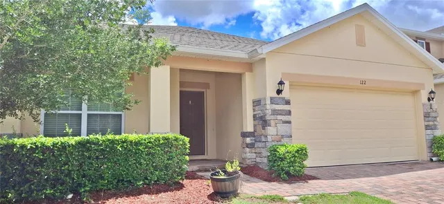 a front view of a house with potted plants