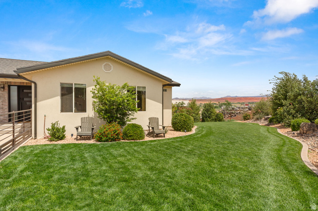 2591 East Washington Dam Road Washington, UT 84780 - Photo 44 of 67 Spacious rear yard featuring an expansive lawn, mature landscaping, and a desert mountain backdrop