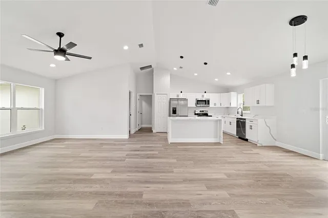 a view of kitchen with stove and white cabinets