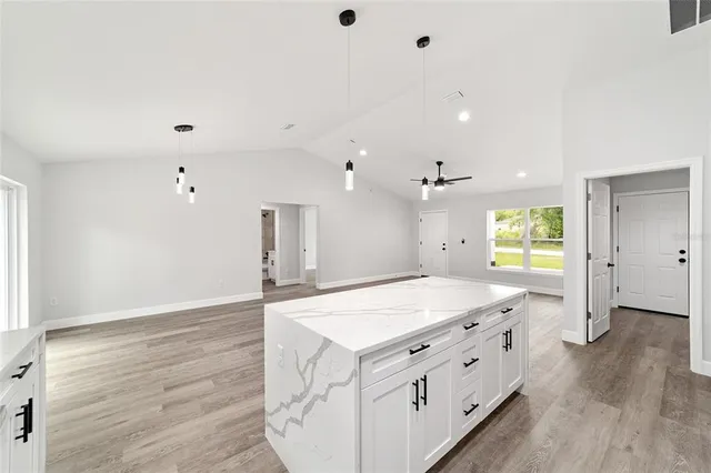 a spacious bathroom with a granite countertop sink a toilet a large mirror and shower