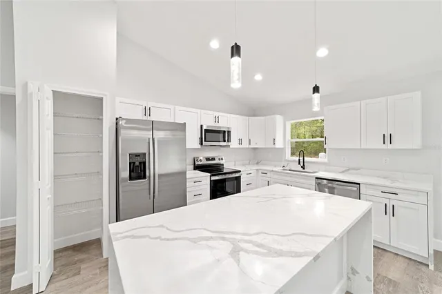 a kitchen with stainless steel appliances a refrigerator sink and microwave